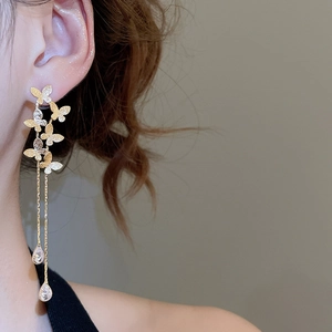 Detail of 18K gold-plated long tassel butterfly earrings with sparkling teardrop crystals
