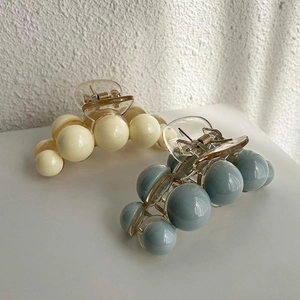 Gros plan de pinces à cheveux élégantes en acrylique blanc crème et bleu brumeux