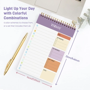Detailed top view of purple spiral planner on white desk with gold pen and accessories