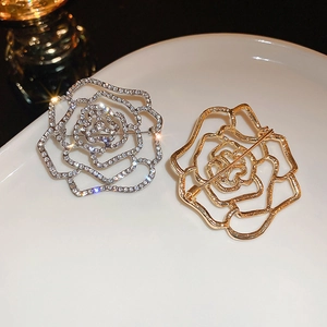 Macro shot of silver crystal flower brooch front and gold pin structure back