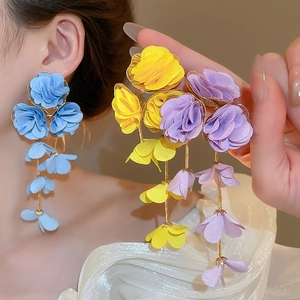 Detail of fabric flower tassel earrings with layered petals and gold-tone metal chains