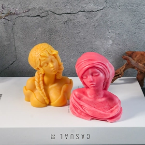 Artistic girl bust handmade candles in yellow and rose red on white decorative books