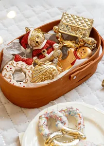Close-up of golden Christmas ornaments including a sequined bear and gingerbread man