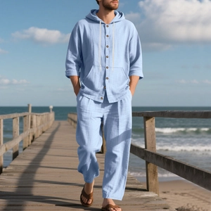 Men's light blue linen set with hooded shirt and trousers on beach wooden walkway