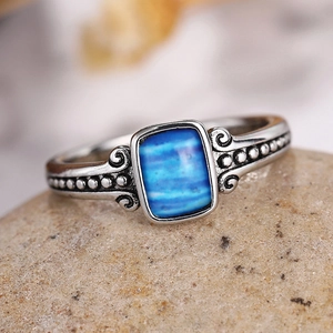 Detailed macro view of vintage silver ring with blue rectangular stone and ornate relief