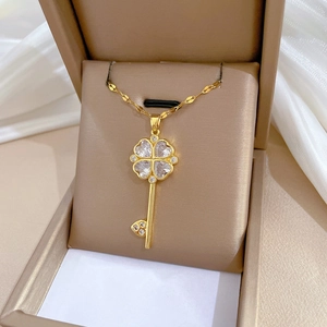 Luxurious gold flower key necklace with diamonds on a delicate chain in a jewelry box
