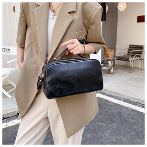 Détail du sac de voyage noir en cuir PU ciré avec pieds métalliques de protection