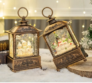 Macro shot of two vintage bronze Christmas lanterns with snowmen inside and LED lights