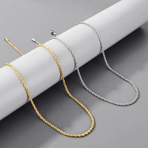 Detail of twisted titanium steel chains in gold and silver showing lobster clasps