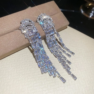 Gros plan de boucles d'oreilles méduse en argent avec zircons sur une boîte à bijoux