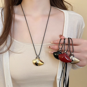 Close-up of irregular geometric metal pendants in gold, silver, black, and red colors