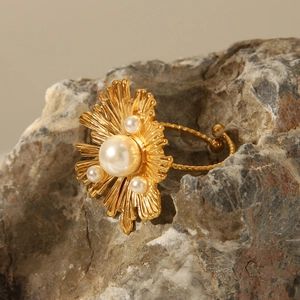 Macro detail of vintage gold pearl ring with sunburst texture on natural rock