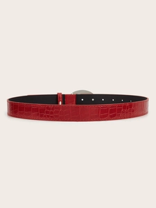 Detail of red faux crocodile leather belt with metallic silver buckle and adjustment holes
