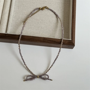 Detailed view of light purple faceted bead necklace with a matching beaded bow pendant