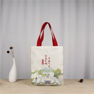 Detail of canvas tote bag featuring traditional Chinese ink painting and red handles
