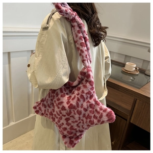 Détail d'un sac à bandoulière en peluche léopard rose porté avec un trench beige