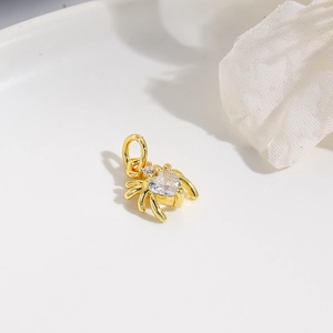 Close-up of a gold spider pendant featuring a heart-shaped zircon and a closed loop ring