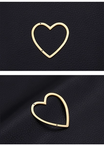 Macro detail of gold-plated heart charms with hollow design for DIY jewelry making