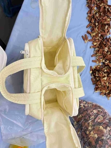 Top view of a pale yellow canvas toiletry bag showing internal compartments and zippers