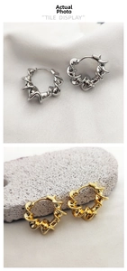 Detailed view of twisted spiral hoop earrings in polished gold and silver metallic finishes