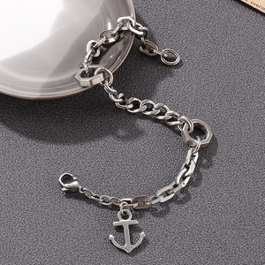 Macro shot of anchor pendant on chunky stainless steel chain bracelet with nut hardware