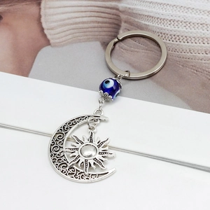 Dettaglio portachiavi boho in argento con sole, luna e perla blu dell'occhio malvagio