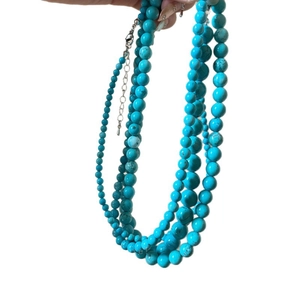 Multilayer turquoise beaded necklace with adjustable lobster clasp on white background