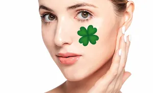 Detailed close-up of a green four-leaf clover temporary face tattoo on a woman's cheek
