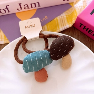 Close-up of cute mushroom fabric hair ties with high elastic brown ropes for girls