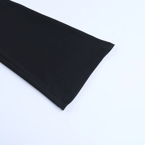 Close-up of the fine stitching and textured black fabric on the flared jumpsuit leg