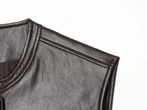 Macro shot of stitching details on dark brown washed PU leather vest shoulder