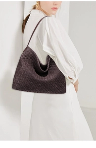 Detail of hand-woven dark brown leather texture and craft on a large hobo tote bag