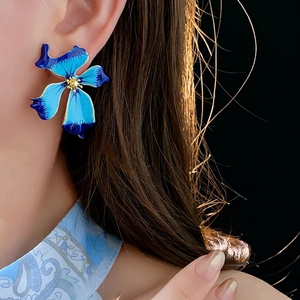 Vintage blue gradient flower earrings with gold pistil and enamel finish on model
