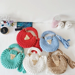 Detail of colorful crochet shoulder bags with metal locks and leather tassels