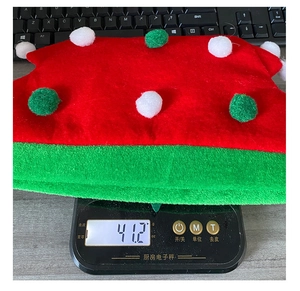 Detailed close-up showing a festive Christmas hat being weighed on a scale, 41.2g weight