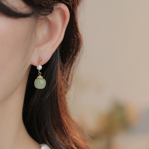 Vintage style drop earrings with freshwater pearls and green nephrite jade on model