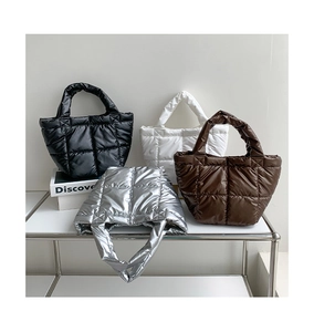 Quilted down fabric handbags in black, white, brown and silver on display rack