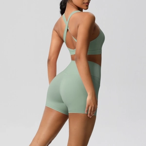 Detail of sage green yoga set showing cross back sports bra and high waist shorts