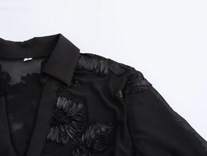 Close-up of black sheer mesh shirt with detailed 3D floral embroidery texture