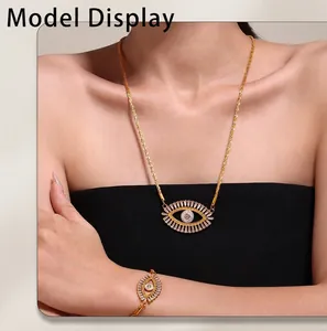Detailed close-up of golden Evil Eye jewelry set with zircon stones on a model wearer
