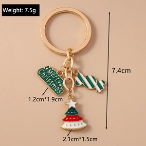 Detail of Christmas keychain with enamel tree, candy cane, and gold Merry Christmas charm