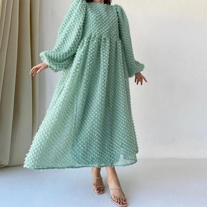 Detail of mint green puff sleeve dress featuring unique 3D textured jacquard fabric
