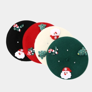 Flat lay of wool berets in black, red, white, and green with 3D Christmas bow ornaments