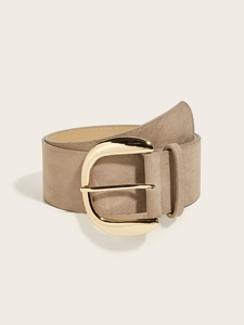 Detail of wide khaki suede belt with a large polished golden round buckle for dresses