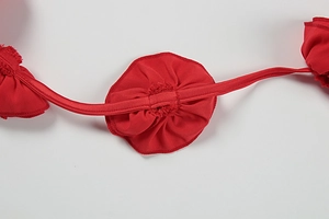 Macro shot of dark red ruffled shoulder strap with fine knitting and center tie detail