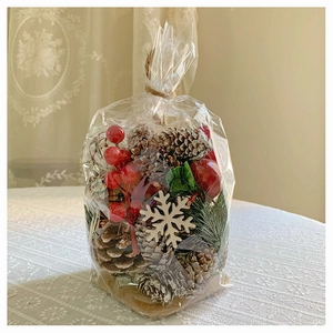 Close-up of Christmas decoration kit with pine cones, red berries and white snowflakes