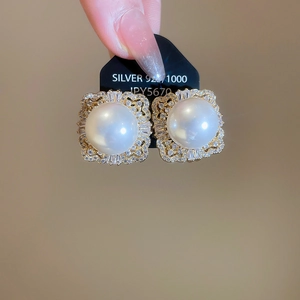 Macro shot of silver 925 geometric pearl earrings with shimmering cubic zirconia accents