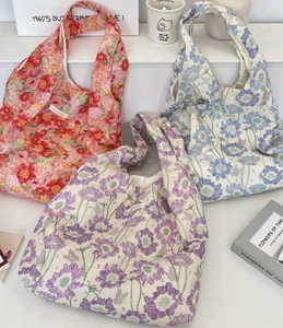 Detailed close-up of floral canvas tote bags with elegant brand labels and interior lining