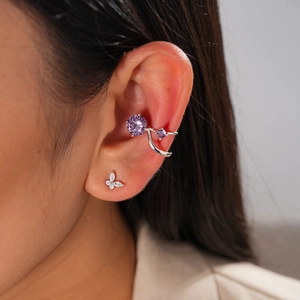 Detail of silver butterfly stud and purple zircon ear cuff on a female model's ear