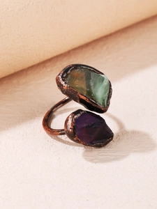 Macro detail of antique copper ring featuring raw green fluorite and purple amethyst gems